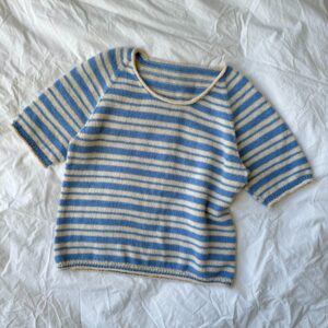 Petiteknit Amélie Tee stickas uppifrån och ner i slätstickning och med ränder. Stickas i en tråd Blenda gotland från Yarnwick.